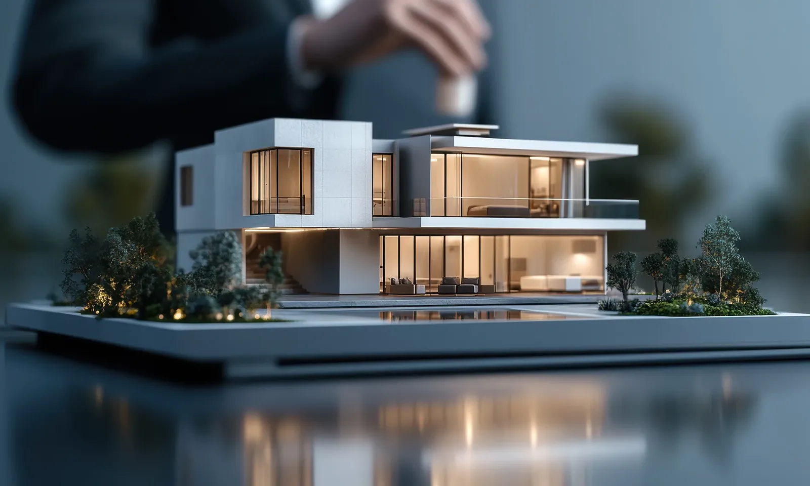 Architekturmodell eines modernen Hauses auf einer spiegelnden Fläche
